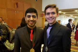 two men in a lobby with medals
