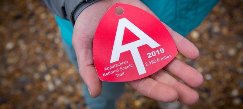 photo of person holding a red baggage tag
