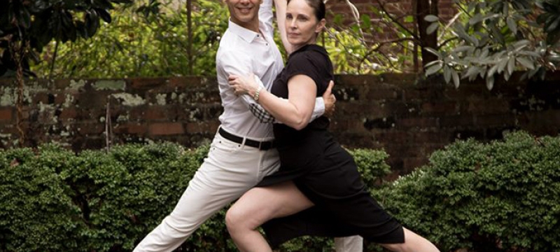photo of two people in a dance pose, garden backdrop
