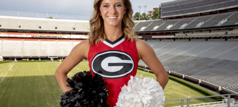 photo of woman in cheerleading outfit at stadium