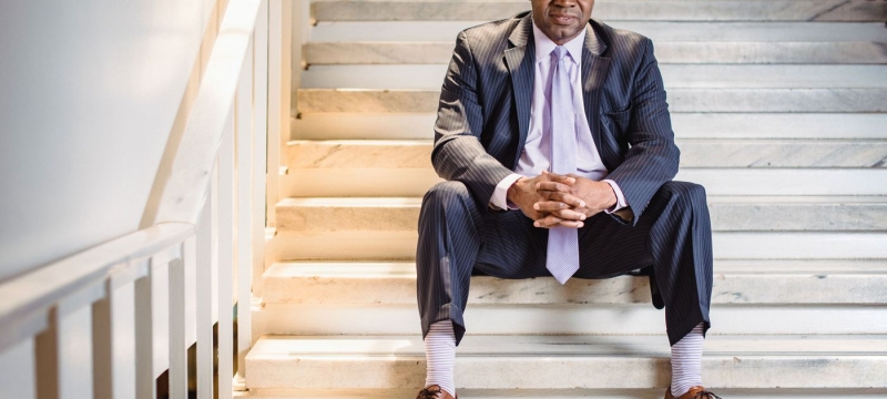 photo of man sitting on stairs in suit.