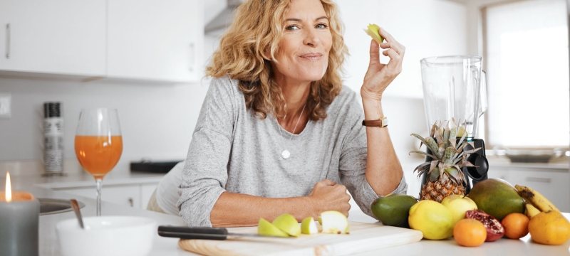 photo of woman leaning on counter, with healthy fruits