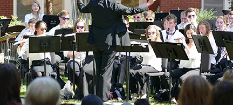 musicians playing outside, with spectators in foreground