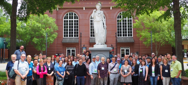 photo of large group of people with statue outdoors