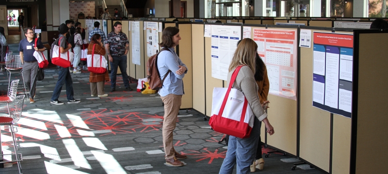 photo of people looking at research posters, indoors