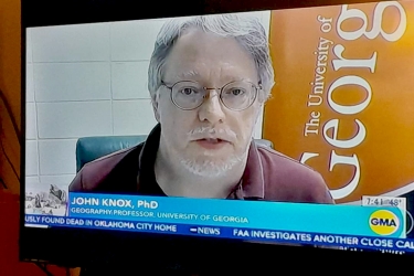 photo of man on screen, with lower third text