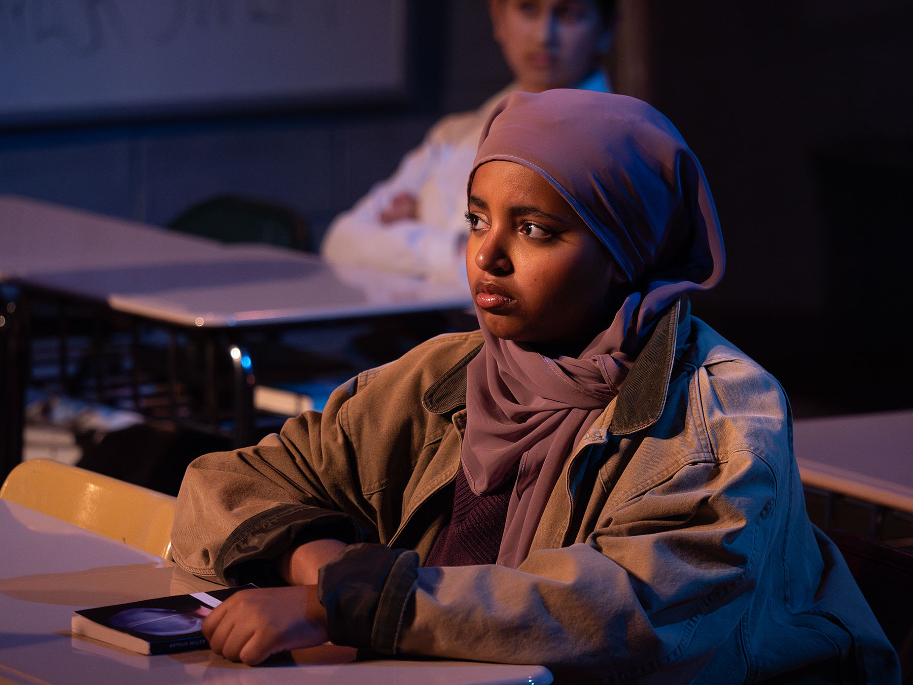 photo of woman, sitting at desk with book