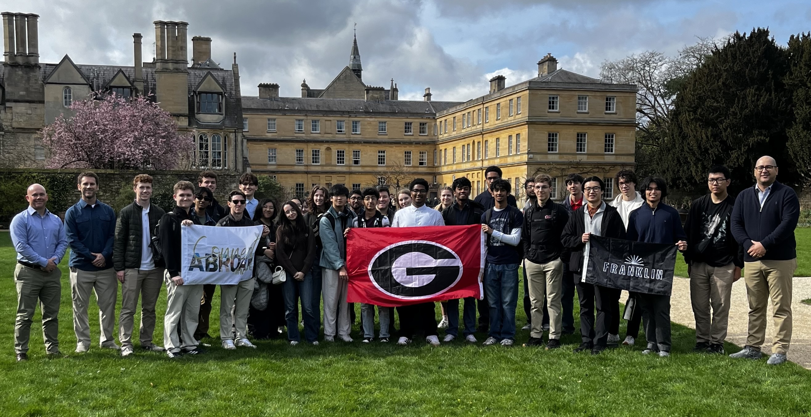 Students holding G banner in front of buildings