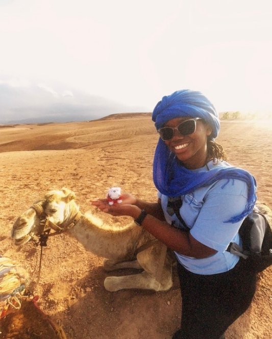 photo of woman with camel, desert in background