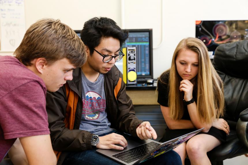 Three students learning on a laptop