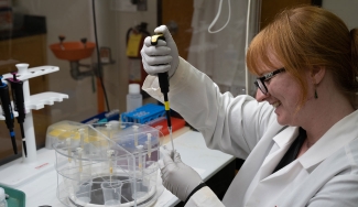 photo of woman with pipette and white coat