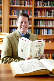 photo of man with book and book shelves