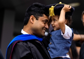 photo of man and child with cap and gown