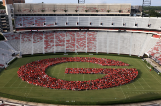 photo of letter G formed by people in stadium, day