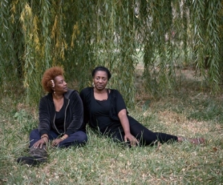 two women sitting beneath a tree
