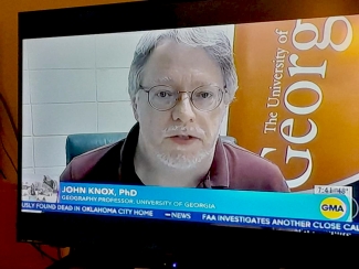 photo of man on screen, with lower third text