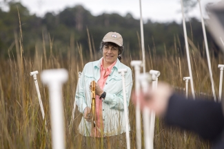 photo of woman in marsh with instruments