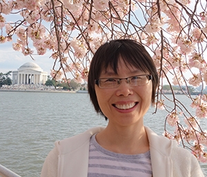 photo of woman with cherry blossom and Lincoln memorial in background
