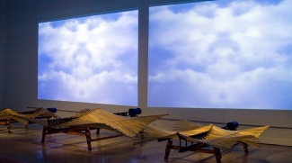 photo of gallery installation with squares of sky and clouds, wood and steel sculptures