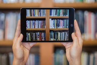 photo of two hands holding an iPad with books image