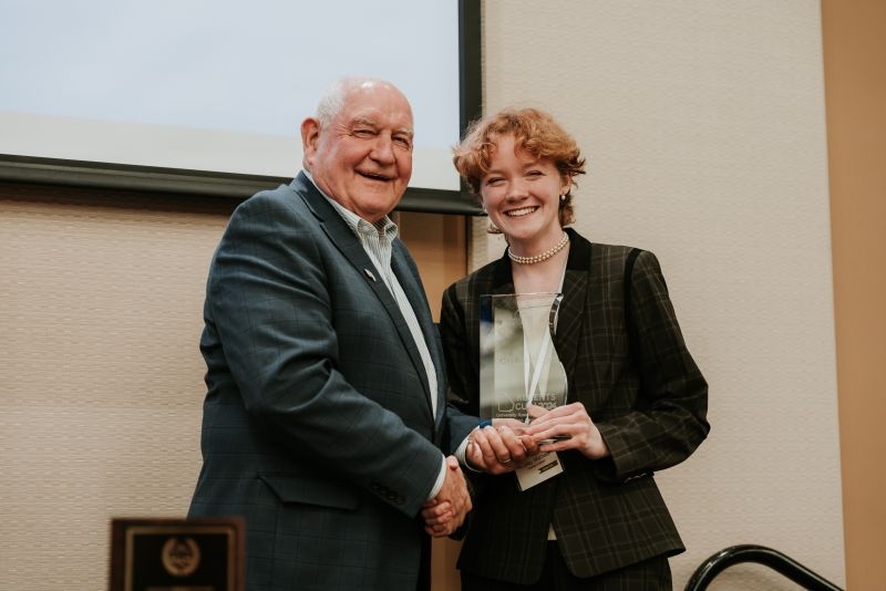 Ansley Warnock presented with the individual champion trophy by USG Chancellor Sonny Perdue