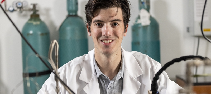 photo of man in lab coat, with lab equipment