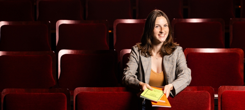 photo of woman sitting in theatre seats
