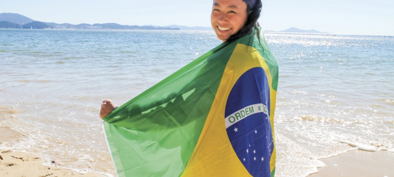 photo of woman on a beach with flag of Brazil
