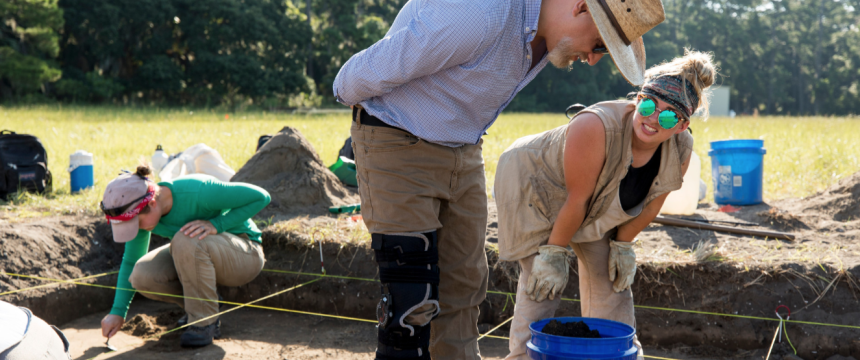 Professor Victor Thompson works with undergraduate student Katelyn Leka as they work on the excavation of their site.