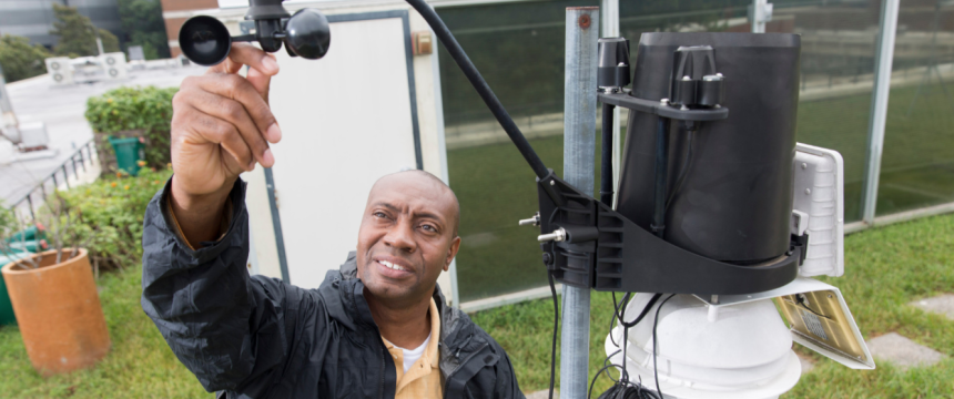 Professor Marshall Shepherd checks a weather station on top of the roof of the Geography Building.