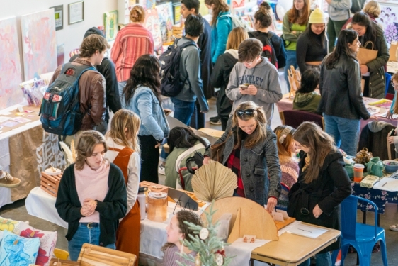 photo of people browsing tables at art market