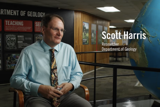 video still photo of man, globe and wall in background