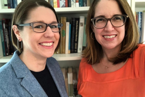 photo of two women in front of bookshelf