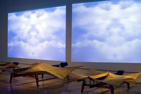 photo of gallery installation with squares of sky and clouds, wood and steel sculptures