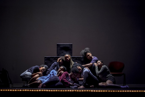 photo of people sitting close together on a darkened stage