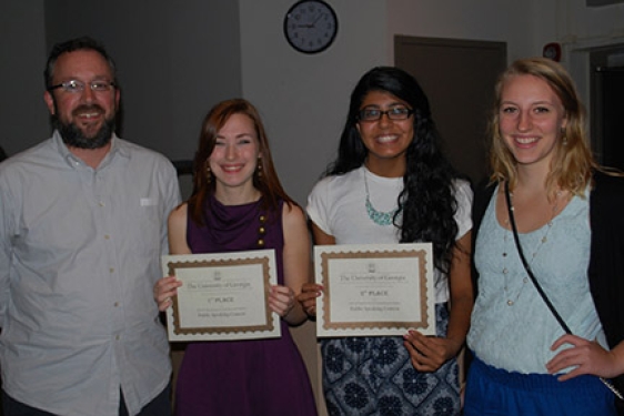 four people, two with certificates, photo