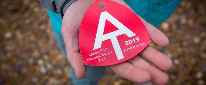 photo of person holding a red baggage tag