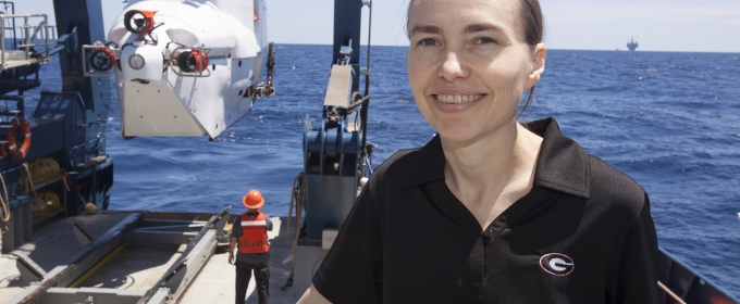 photo of woman aboard ship, ocean in background