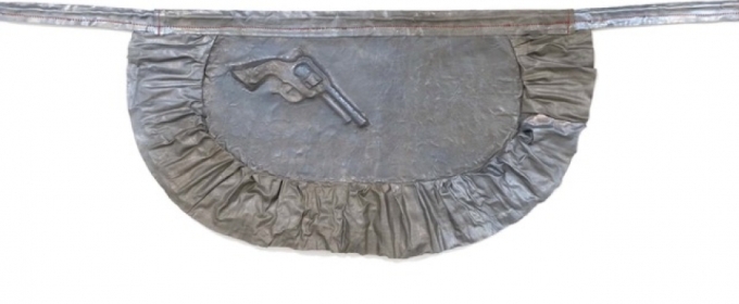 metal sculpture of apron with pistol