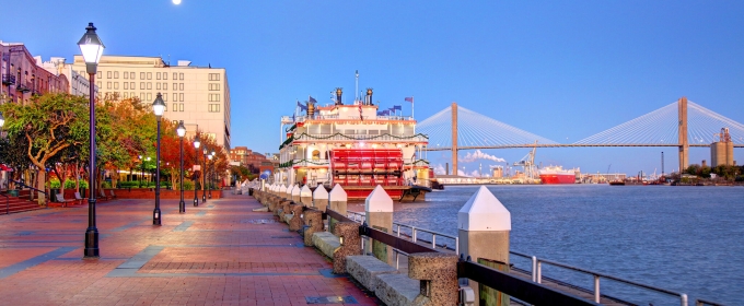 photo of docked riverboat, river, bridge in background