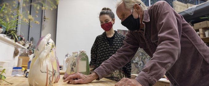 photo of two people in masks in art studio