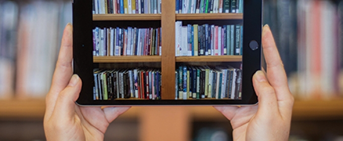 photo of two hands holding an iPad with books image